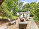 Inviting backyard with a gravel firepit area surrounded by mature trees and string lights at 1723 Woodland Dr, Charlotte, NC 28205