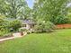 Green backyard features a patio area with furniture, trees, and landscape providing a cozy outdoor retreat at 1723 Woodland Dr, Charlotte, NC 28205