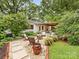 Charming backyard patio with seating, a pergola, and lush landscaping for outdoor enjoyment at 1723 Woodland Dr, Charlotte, NC 28205