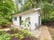 Backyard featuring a guest house with a well-maintained garden and stone pathway at 1723 Woodland Dr, Charlotte, NC 28205