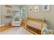 Bright Bedroom showcasing a wooden crib, comfortable armchair, and playful decor at 1723 Woodland Dr, Charlotte, NC 28205