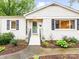 Close-up of a well-maintained home exterior with black shutters, a green door, and a lovely entry at 1723 Woodland Dr, Charlotte, NC 28205