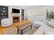 Cozy living room featuring hardwood floors, a brick fireplace, built-in bookshelves and a modern sofa at 1723 Woodland Dr, Charlotte, NC 28205