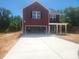 New two story home with a red exterior, a large front lawn, and a two-car garage at 2300 Grayson Pkwy, Monroe, NC 28110