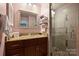 Updated bathroom featuring granite vanity top, decorative mirror and glass shower with tiled walls at 2533 Stockbridge Dr, Charlotte, NC 28210