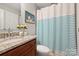 Clean bathroom with a granite vanity and a shower-tub combination with a striped curtain at 2533 Stockbridge Dr, Charlotte, NC 28210