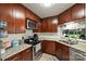 Well-lit kitchen featuring dark wood cabinets, stainless steel appliances, and granite countertops at 2533 Stockbridge Dr, Charlotte, NC 28210