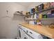 Functional laundry room featuring a washer, dryer, counter space, and storage shelves at 2533 Stockbridge Dr, Charlotte, NC 28210