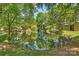 Scenic pond surrounded by lush greenery, with reflections of trees and sky at 2533 Stockbridge Dr, Charlotte, NC 28210