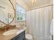 Charming bathroom with a marble vanity, decorative mirror, and a shower with a white curtain at 2919 Wickersham Rd, Charlotte, NC 28211