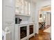 Elegant wet bar with glass-front cabinets, wine cooler, and ample storage, conveniently located near the kitchen at 2919 Wickersham Rd, Charlotte, NC 28211