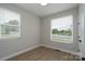 Bright bedroom with two windows, wood-look flooring, and neutral walls at 304 Cabarrus W Ave, Concord, NC 28025