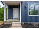 Inviting front entrance with white door, brick steps, and stylish lighting fixtures to welcome you home at 304 Cabarrus W Ave, Concord, NC 28025