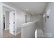 Upstairs hallway with wood-look flooring, modern lighting, and white doors at 304 Cabarrus W Ave, Concord, NC 28025