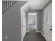 Bright, neutral hallway featuring modern gray flooring, access to stairs, and natural light through the front door at 315 E Washington Ave, Bessemer City, NC 28016