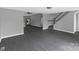 Open-concept living room with stairs, modern gray flooring, and neutral paint, creating a bright and airy atmosphere at 315 E Washington Ave, Bessemer City, NC 28016