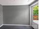 An empty room with gray walls and modern dark floors is illuminated by light from the exterior door at 315 E Washington Ave, Bessemer City, NC 28016