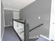 A staircase with gray walls and white railings descends to the lower floor at 315 E Washington Ave, Bessemer City, NC 28016