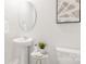Clean and well-lit bathroom with a modern pedestal sink, toilet, and stylish decor at 3734 Coleman Dr, Charlotte, NC 28215