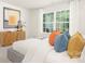 Serene bedroom showcases a large window for natural light, a stylish accent cabinet, and a comfortable bed with colorful pillows at 3734 Coleman Dr, Charlotte, NC 28215