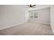 Bedroom with plush carpet, ceiling fan and a large window at 3926 Litchfield Rd, Charlotte, NC 28211
