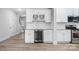 Eat in kitchen features white cabinets, a beverage cooler, modern lighting, stainless appliances, and hardwood floors at 3926 Litchfield Rd, Charlotte, NC 28211