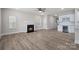 Open-concept living room with fireplace, ceiling fan, and a modern kitchen with stainless steel wine cooler at 3926 Litchfield Rd, Charlotte, NC 28211