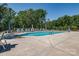Community pool surrounded by lush greenery, lounge chairs, and ample seating at 4014 Pleasant Run Dr, Stallings, NC 28227
