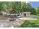 Inviting backyard patio area with stone fire pit, charming gazebo, and a small private outbuilding at 420 S Cedar St, Lincolnton, NC 28092