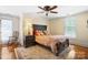 Cozy bedroom featuring hardwood floors, a ceiling fan, a rocking chair, and natural light at 420 S Cedar St, Lincolnton, NC 28092