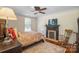 Comfortable bedroom featuring wood floors, a ceiling fan, and a decorative fireplace at 420 S Cedar St, Lincolnton, NC 28092