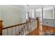 Upstairs hallway featuring hardwood floors, white railings, and decorative hanging light fixture at 420 S Cedar St, Lincolnton, NC 28092