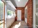 Sunroom with brick wall, wood ceiling and floors, and view of trees at 435 W Whitley St, Norwood, NC 28128