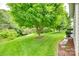 Well-manicured backyard with lush lawn, mature trees, and patio along the home at 539 Turquoise Way, Fort Mill, SC 29708