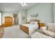 Large primary bedroom with a ceiling fan, floral furniture, and carpet flooring at 539 Turquoise Way, Fort Mill, SC 29708