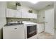 Clean laundry room with white cabinets, countertop, and modern washer and dryer appliances at 539 Turquoise Way, Fort Mill, SC 29708