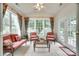 Bright sun room with wicker furniture, floral curtains, and large windows at 539 Turquoise Way, Fort Mill, SC 29708