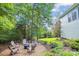 Beautiful backyard with a stone fire pit area surrounded by lush greenery and mature trees at 5424 Morris Hunt Dr, Fort Mill, SC 29708