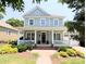 Inviting two-story home featuring a spacious front porch, manicured lawn, and vibrant landscaping at 5424 Morris Hunt Dr, Fort Mill, SC 29708