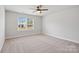 This bedroom features neutral paint, carpet flooring, and a window that allows for natural light at 6712 W Sugar Creek Rd, Charlotte, NC 28269
