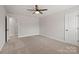 This bedroom features neutral paint, carpet flooring, a ceiling fan, and a white door at 6712 W Sugar Creek Rd, Charlotte, NC 28269