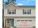 Charming two-story home with a modern exterior, stone accents, and an attached garage with a teal front door at 6712 W Sugar Creek Rd, Charlotte, NC 28269