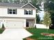 Charming two-story home featuring stone accents, a two-car garage, and a well-manicured lawn at 6712 W Sugar Creek Rd, Charlotte, NC 28269
