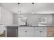Bright kitchen island with a stainless steel dishwasher and contemporary pendant lighting, perfect for casual dining and entertaining at 6712 W Sugar Creek Rd, Charlotte, NC 28269