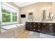 Elegant bathroom with a soaking tub, dual vanities, and a large window overlooking the landscape at 6873 Pine Moss Ln, Clover, SC 29710