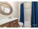 Bathroom with wood cabinets, granite countertops, and blue shower curtain at 6873 Pine Moss Ln, Clover, SC 29710