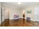Spacious room with hardwood floors, colorful wall art and a glimpse of a bathroom at 6873 Pine Moss Ln, Clover, SC 29710