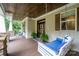 Inviting covered porch with a swing, rocking chairs, wood ceiling, and stone accents at 6873 Pine Moss Ln, Clover, SC 29710