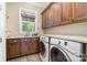 Well-equipped laundry room features wood cabinets, sink, counter space, and modern washer and dryer at 6873 Pine Moss Ln, Clover, SC 29710