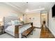 Well-lit bedroom with neutral tones, a tufted headboard, and bench seating at the foot of the bed at 6873 Pine Moss Ln, Clover, SC 29710